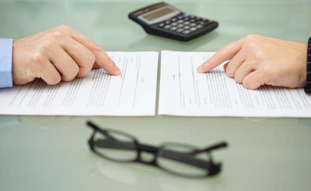 Man and woman pointing at a paper on a desk 